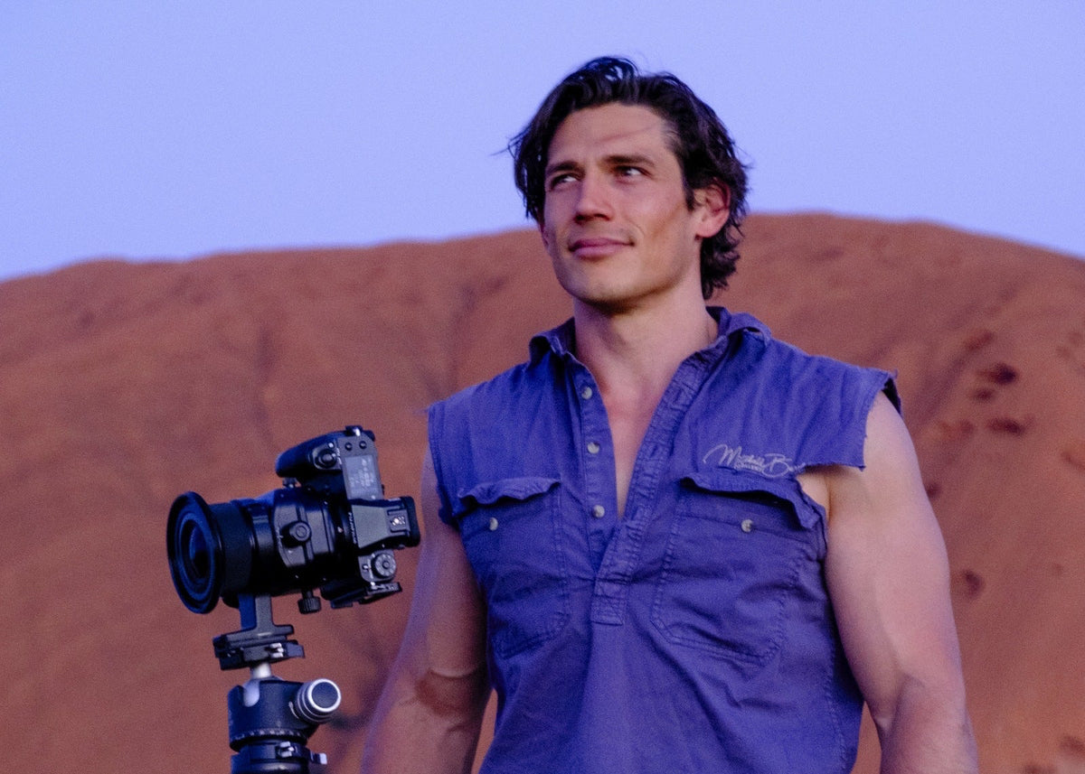 Mitchell Burns with camera in the Australian outback